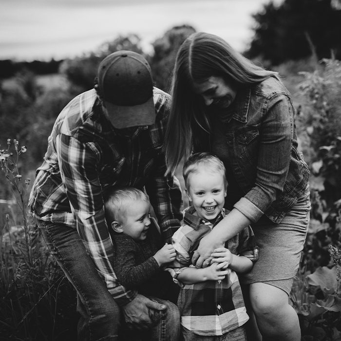 black and white family of four tickling each other and laughing - family gallery link image