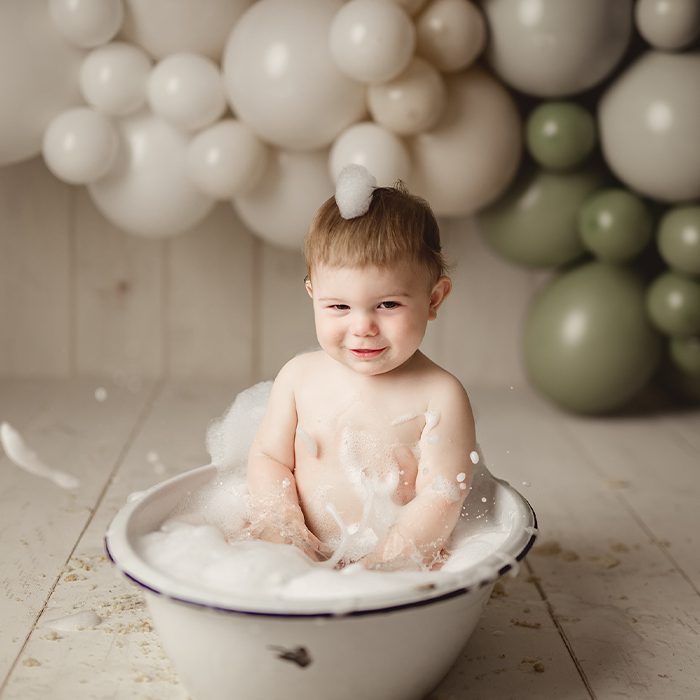 one year old splashing in antique bath tub - milestone gallery link